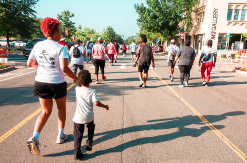 Color photo of Black woman with red hair and her son running in the Little Rock Arkansas Mosaic Templars Juneteenth 5k