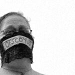 black and white photo of woman wearing mask that says Of SCOTUS at rally for reproductive rights at State Capitol in Little Rock Arkansas