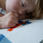 color photo close up of boy drawing with magic markers