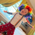 color photo of boy playing dress up as a clown