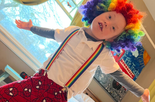 color photo of boy playing dress up as a clown