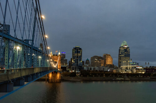 Color photograph of Cincinnati skyline from lookout point on Roebling Suspension Bridge over the Ohio River.
