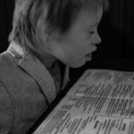 Black and white photograph of boy reading dinner menu at Bruno’s Little Italy in Little Rock, Arkansas