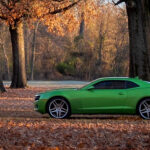 color photograph of green dodge charger parked in orange foliage along arkansas river near north little rock arkansas
