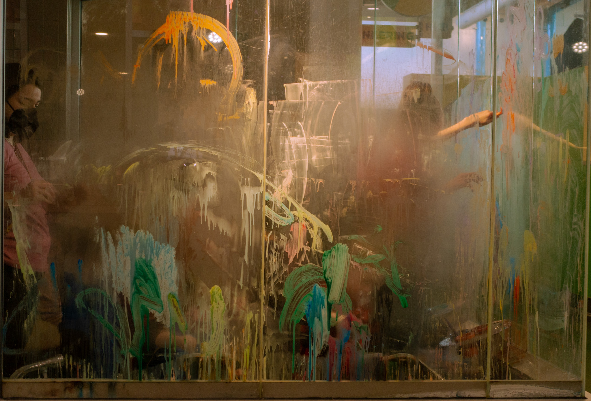 Color photograph of parents and children painting on fiberglass wall at Scott family amazeum in Bentonville, Arkansas