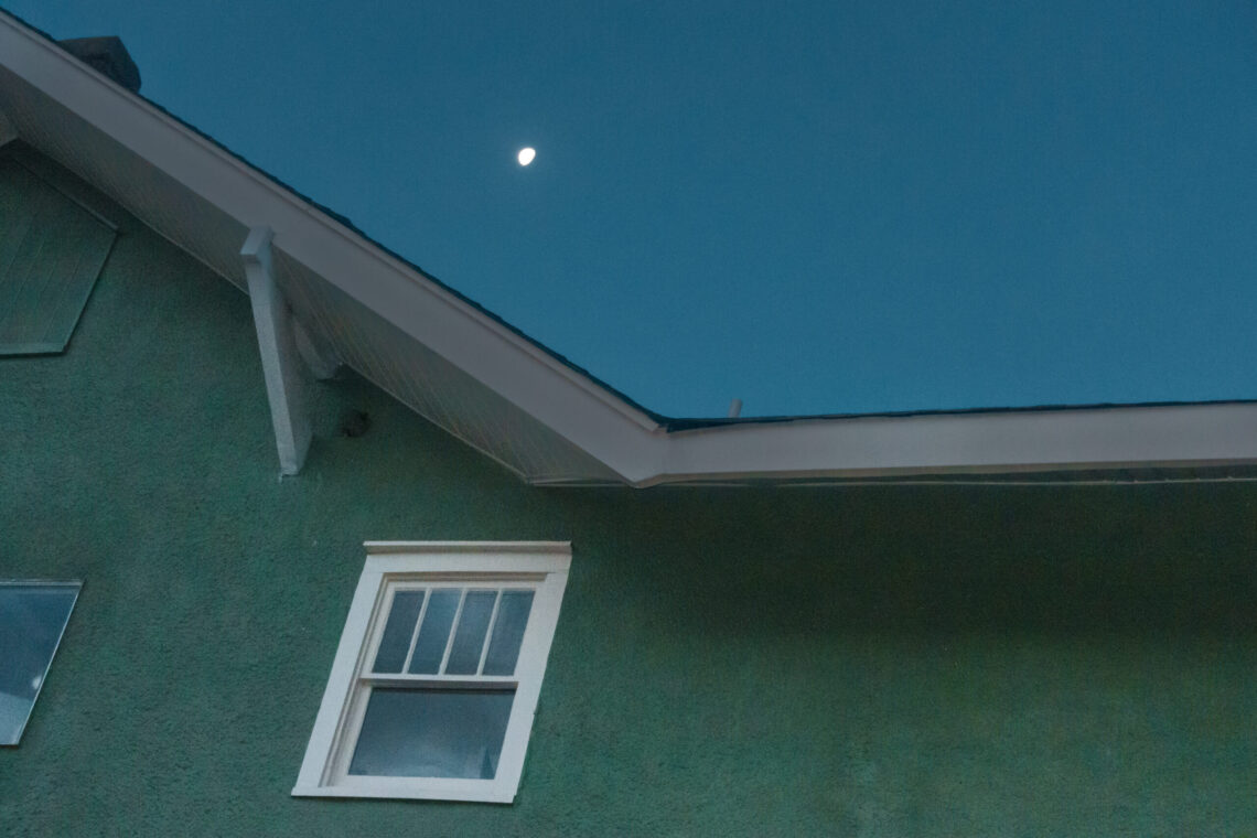 Color urban landscape photograph of last moon of 2022 rising over house in the Dunbar Historic neighborhood of little rock arkansas