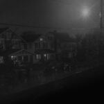 black and white photograph of rain on street under street light in Historic Wright Avenue Neighborhood in Little Rock Arkansas